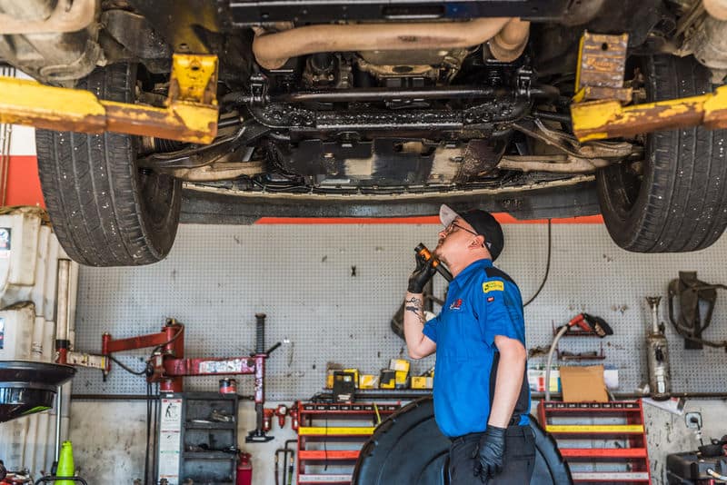 Technician looking underneath vehicle