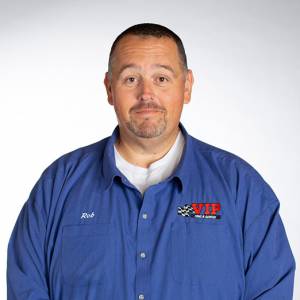 Man wearing a blue work shirt with an embroidered logo, photographed against a white background.