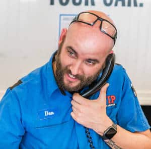 Man in blue shirt wearing glasses on his head holds a stethoscope around his neck.