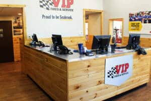 VIP Tires & Service reception desk with wooden paneling and computer monitors.