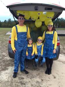 couple and their two children dressed up as minions for trunk or treat