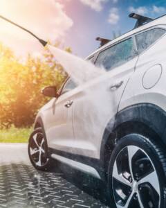 Pressure washing a silver car
