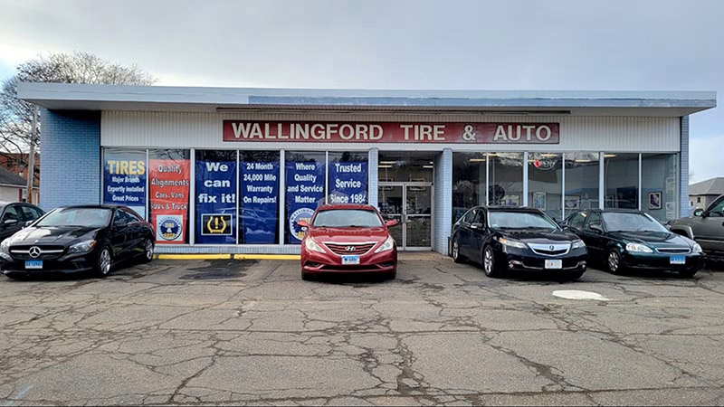Wallingford Tire & Auto storefront with several vehicles parked in front.