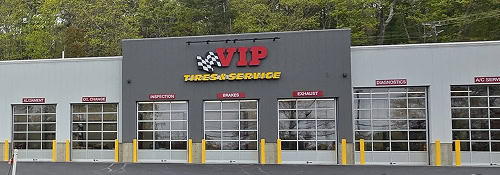 An ATS auto service facility with multiple garage bays and yellow safety bollards.
