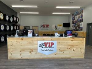 VIP Tires & Service reception desk with wooden counter, tire displays, and Portland location.