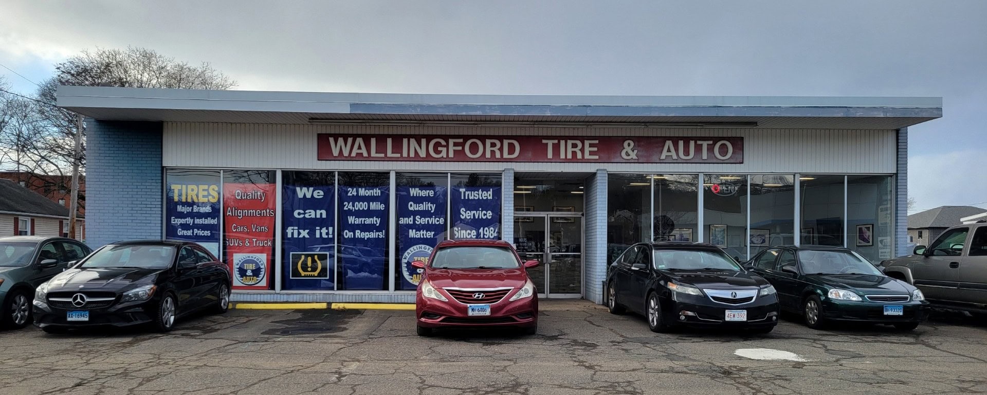 Wallingford Tire & Auto storefront with parked vehicles and service signs displayed.
