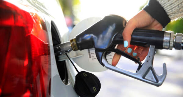 Hand pumping gasoline fuel in car
