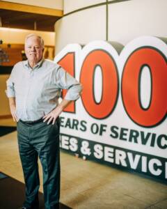 John Quirk with 100 year sign